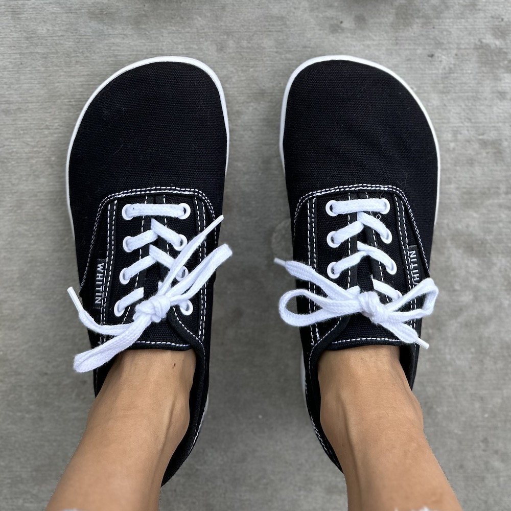 a top down view of a pair of feet wearing Whitin cheap barefoot sneakers that look like Vans