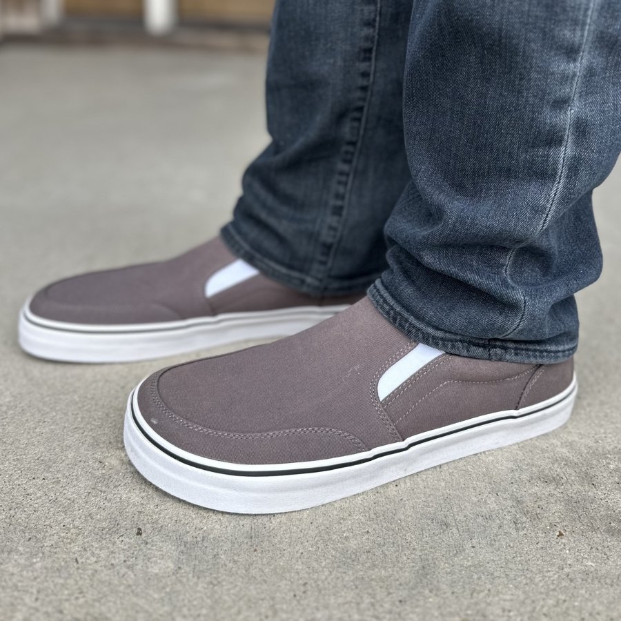Side view close up of a man's legs in gray canvas barefoot slip-ons from Splay Shoes. The Streetstyle sneaker is worn with denim and the side profile shows the zero drop chunky outsole